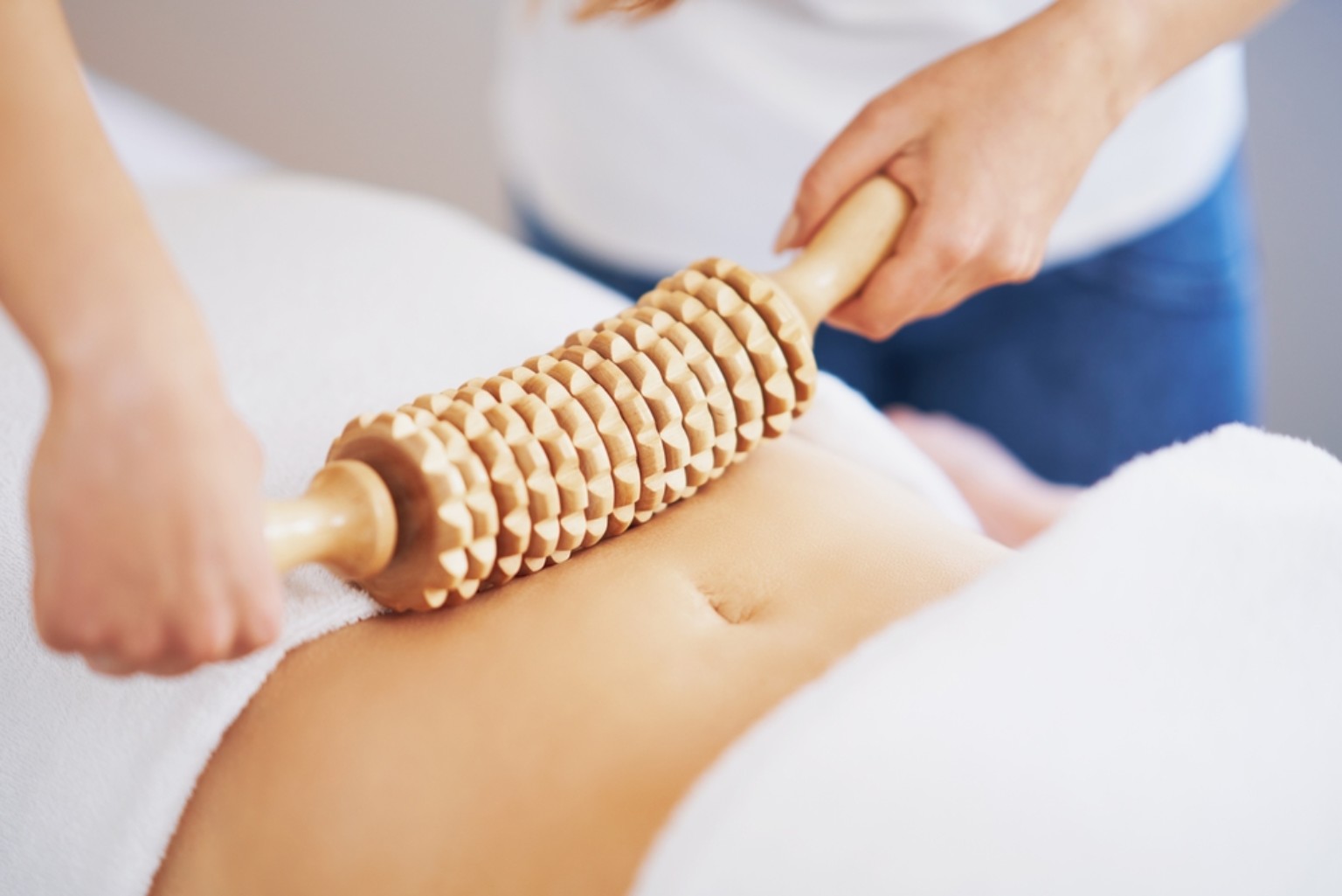 Voorbeeld van een houten massageroller tijdens een buikbehandeling